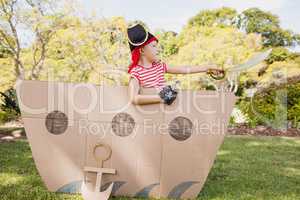 Young boy with fancy dress playing on a cardboard boat