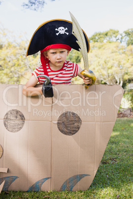 Portrait of a child with fancy dress inside a cardboard boat