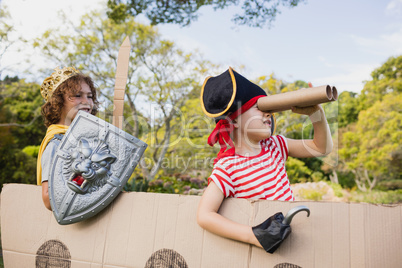 Portrait of children with fancy dress playing on cardboard boat