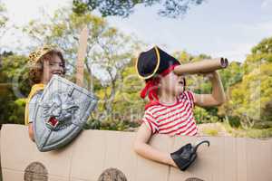 Portrait of children with fancy dress playing on cardboard boat