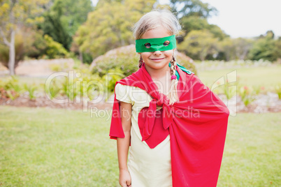Cute girl with superhero dress smiling and posing