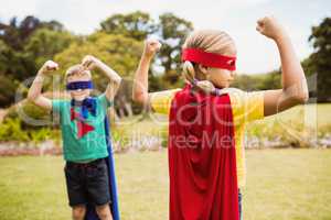 Children with superhero dress showing their muscles