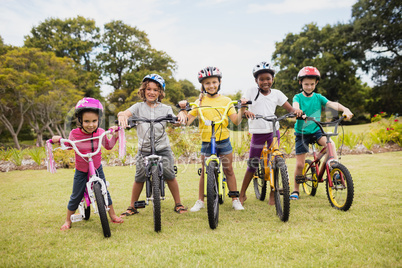 Happy children wearing helmet and posing on their bike