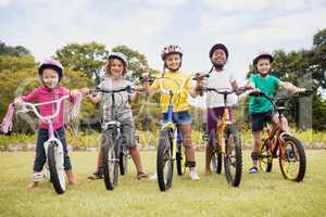 Happy children wearing helmet and posing on their bike