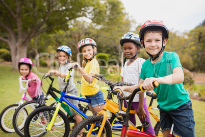 Children wearing helmet and posing on their bike