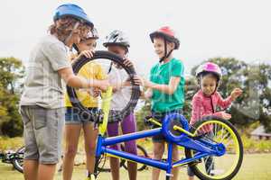 Children wearing helmet and touching bike