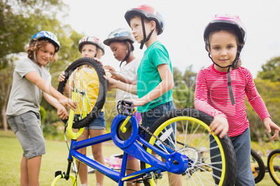 Children wearing helmet and touching bike