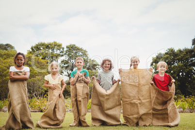 Children smiling and posing inside bag
