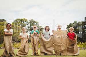 Children smiling and posing inside bag