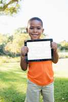 Portrait of young black boy showing a tablet