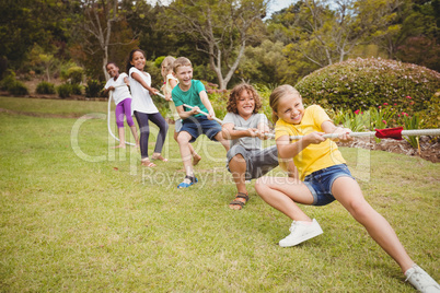 Children smiling and playing with a rope
