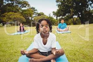 Portrait of a young boy doing yoga with other children