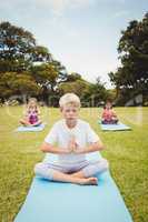 Portrait of a young boy doing yoga with other children