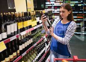 Woman looking at wine bottle