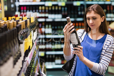 Woman looking at wine bottle