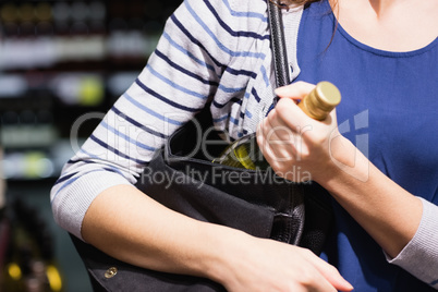Woman putting a wine bottle in her bag