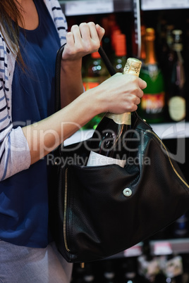 Woman putting a wine bottle in her bag