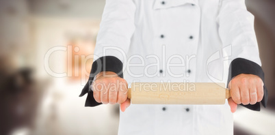 Composite image of close up on a chef holding a rolling pin