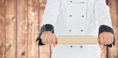 Composite image of close up on a chef holding a rolling pin