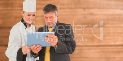 Composite image of businessman and female chef using digital tablet