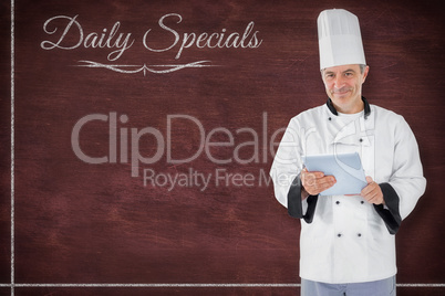 Composite image of chef standing holding a document