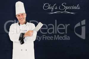 Composite image of friendly chef holding a knife