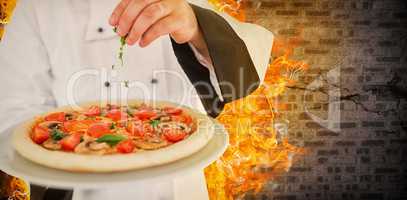 Composite image of close up on a chef holding a pizza