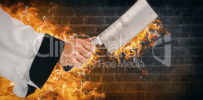 Composite image of chef hand holding a knife