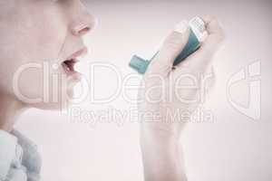 Composite image of close up of a woman using an asthma inhaler