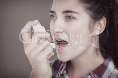 Composite image of woman having asthma using the asthma inhaler
