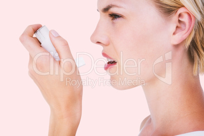 Composite image of asthmatic pretty blonde woman using inhaler