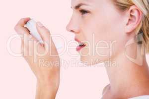 Composite image of asthmatic pretty blonde woman using inhaler