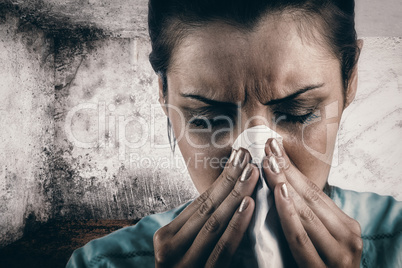 Composite image of portrait of woman blowing her nose