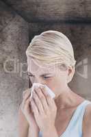 Composite image of portrait of woman blowing her nose