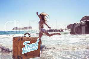 Composite image of beautiful smiling woman in white bikini skipping on the beach