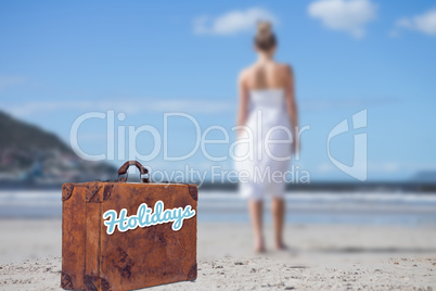 Composite image of blonde in white dress walking on the beach