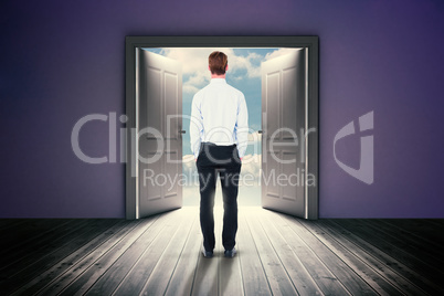 Composite image of rear view of businessman with hands in pockets