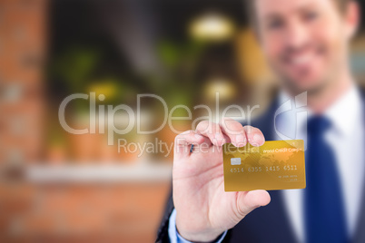 Composite image of happy businessman showing a creditcard