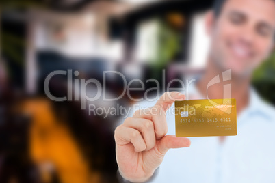 Composite image of happy businessman showing a credit card
