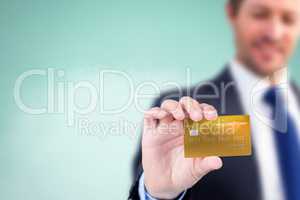 Composite image of businessman showing a creditcard