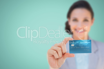 Composite image of happy businesswoman showing a creditcard