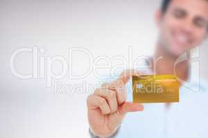Composite image of happy businessman showing a credit card