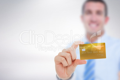 Composite image of happy businessman showing a creditcard