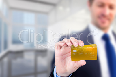 Composite image of businessman showing a creditcard