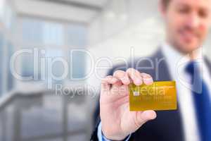 Composite image of businessman showing a creditcard