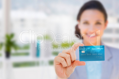 Composite image of happy businesswoman showing a creditcard