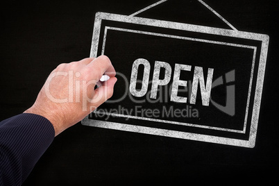 Composite image of hand of a businessman writing with a chalk