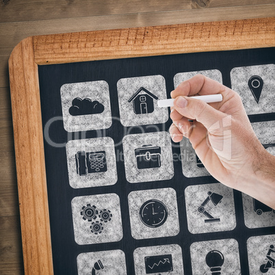 Composite image of hand holding a chalk and writing something