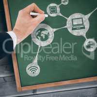 Composite image of hand of businessman writing with a white chalk