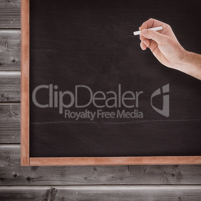 Composite image of hand holding a chalk and writing something